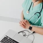 Lekarz w trakcie konsultacji online przed laptopem - jak przygotować się na wdrożenie KSeF dla zwolnionych z VAT w 2026 roku.